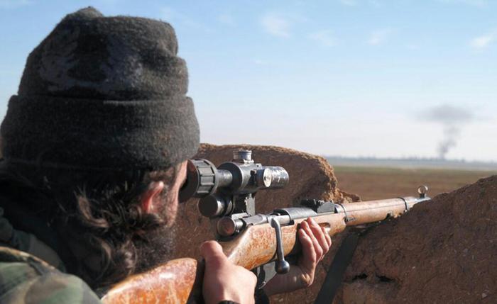 In this image posted on a militant social media account by the Al-Baraka division of the Islamic State group on Tuesday, Feb. 24, 2015, a militant fighter aims a sniper rifle during during fighting in Tal Tamr, Hassakeh province, Syria. Fierce fighting between Kurdish and Christian militiamen and Islamic State militants is continuing on Wednesday, Feb. 25 in northeastern Syria where the extremist group recently abducted at least 70 Christians. (ANSA/AP Photo via militant social media account)