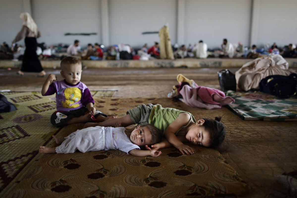 A AUG. 26, 2012 FILE PHOTO FILE - In this Aug. 26, 2012, file photo, Syrian children who fled their home with their family due to fighting between the Syrian army and the rebels, lie on the ground while they and others take refuge at the Bab Al-Salameh border crossing, in hopes of entering one of the refugee camps in Turkey, near the Syrian town of Azaz. Marking a tragic milestone, the United Nations said in a statement on Thursday, July 9, 2015 that over 4 million Syrians have fled to other countries since the outbreak of civil war in their country more than four years ago. (AP Photo/Muhammed Muheisen, File)