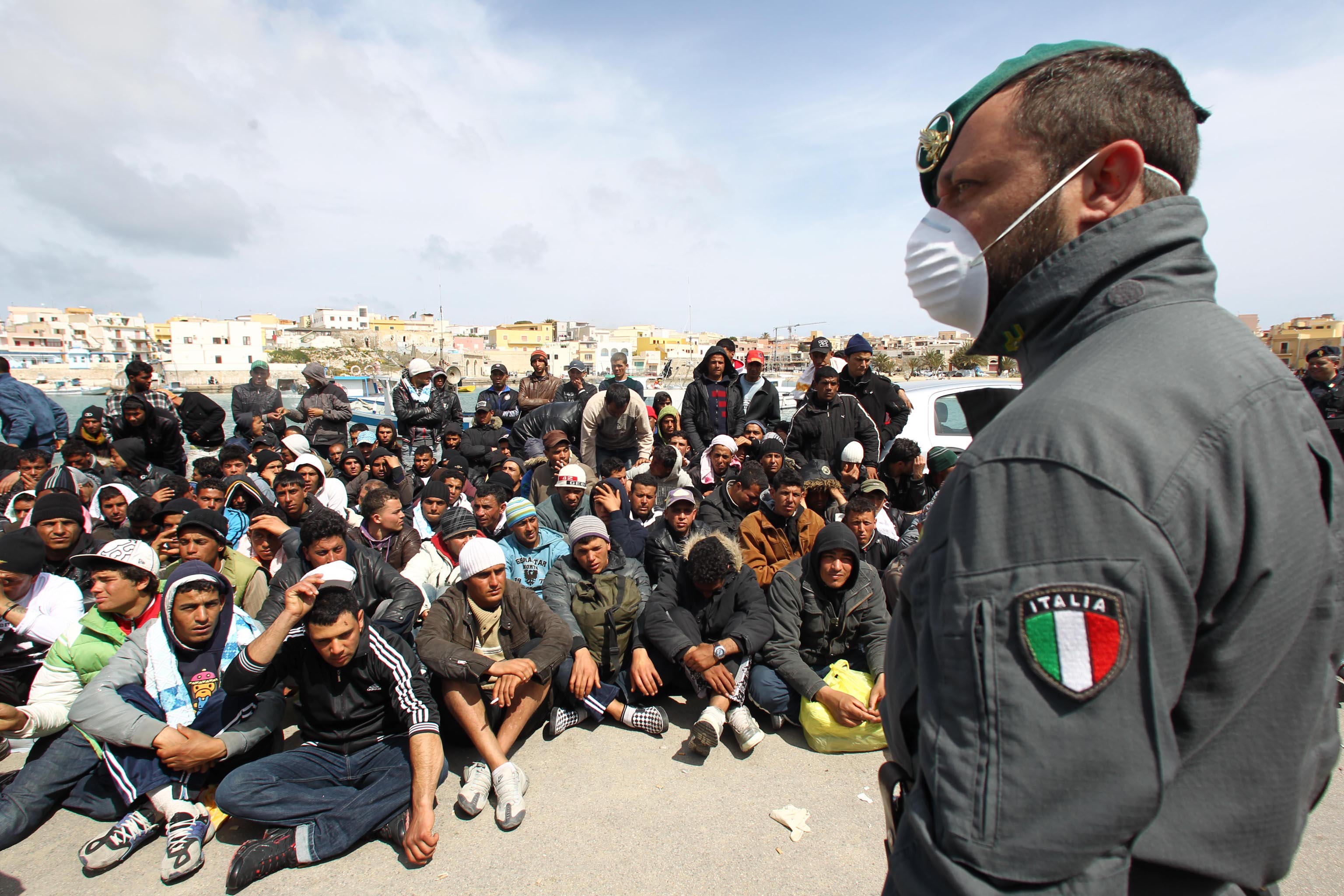 Gruppi di migrati riuniti per l'identificazione dalle forze dell'ordine a Lampedusa, oggi 29 marzo 2011. Nell'isola i migranti presenti sono 6.200, il dato e' fornito dall'ufficio della Regione siciliana. ANSA / FILIPPO VENEZIA
