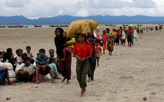 Rohingya+refugees+walk+to+a+Border+Guard+Bangladesh+(BGB)+post+after+crossing+the+Bangladesh-Myanmar+border+by+boat+through+the+Bay+of+Bengal+in+Shah+Porir+Dwip,+Bangladesh,+September+10,+2017