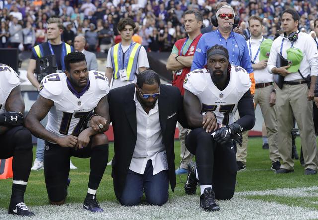 Baltimore Ravens wide receiver Mike Wallace, from left, former player Ray Lewis and inside linebacker C.J. Mosley lock arms and kneel down during the playing of the U.S. national anthem before an NFL football game against the Jacksonville Jaguars at Wembley Stadium in London, Sunday Sept. 24, 2017. (ANSA/AP Photo/Matt Dunham) [CopyrightNotice: Copyright 2017 The Associated Press. All rights reserved.]