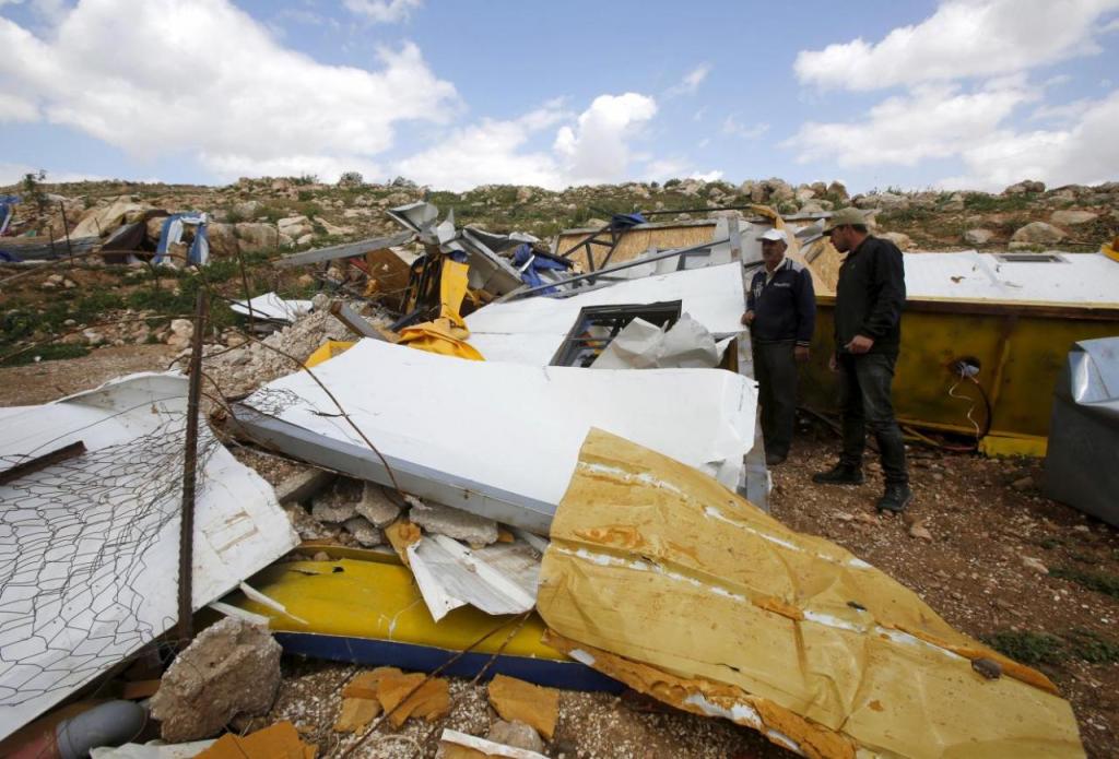 Palestinians look at the remains of a school project that was funded by the European Commission Humanitarian Aid and Civil Protection (ECHO) and was demolished by Israeli forces, in Khirbet Tana near the West Bank city of Nablus March 29, 2016. REUTERS/Abed Omar Qusini